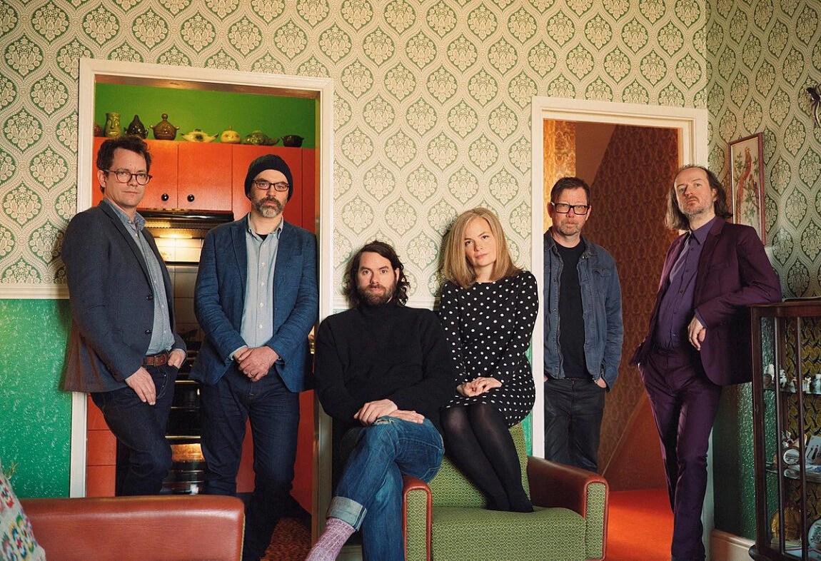 Six members of the band Tunng, photographed in a living room.